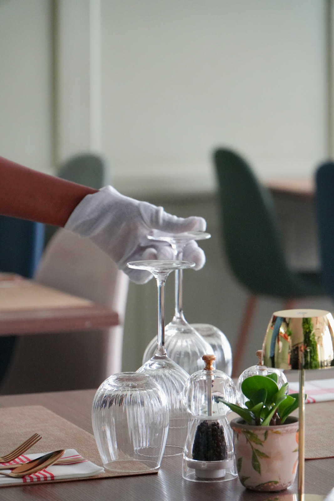 Waiter in white gloves setting the glasses at A Tavola
