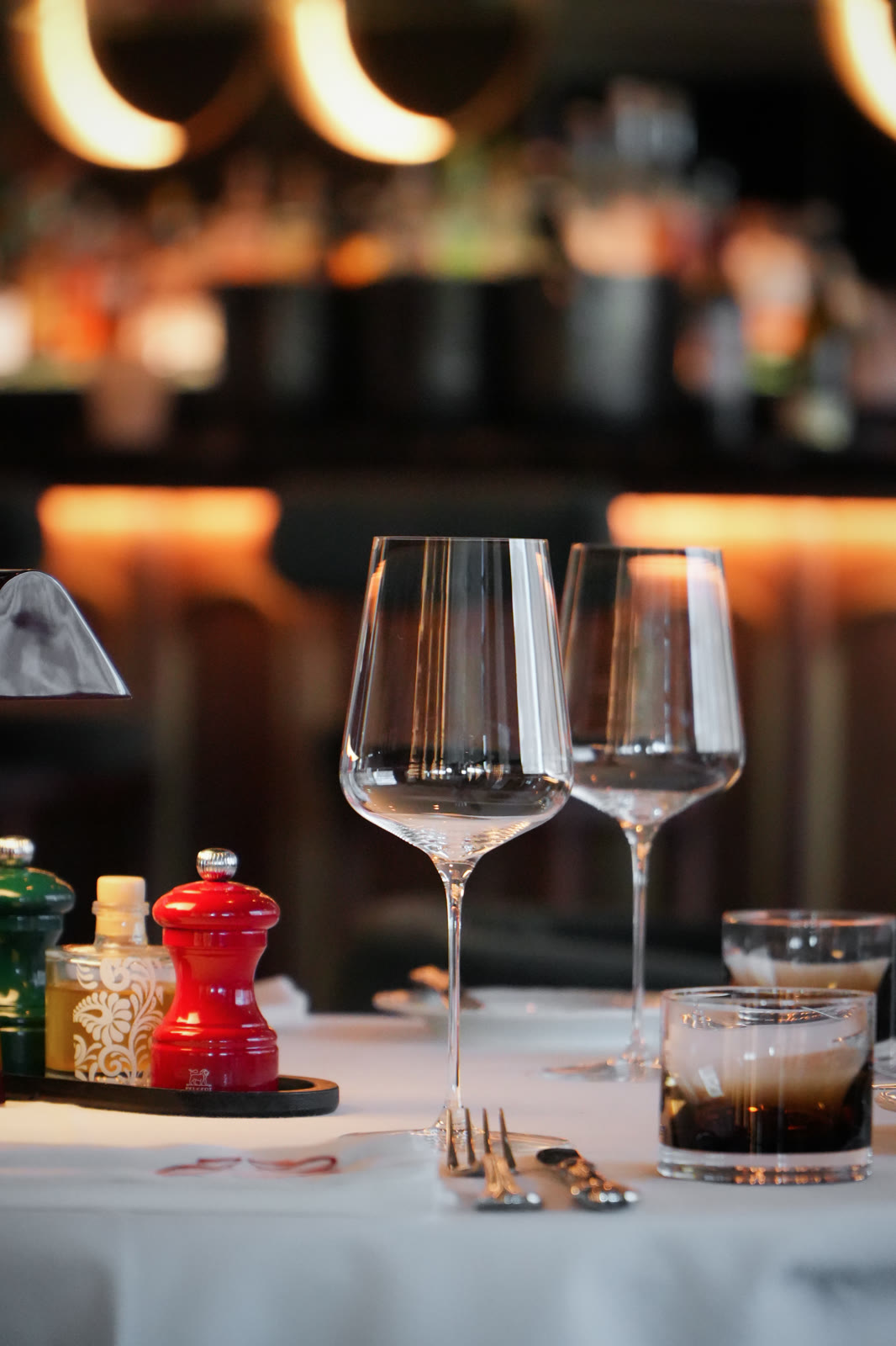 Verres et table dressée en lumière tamisée, restaurant Jane