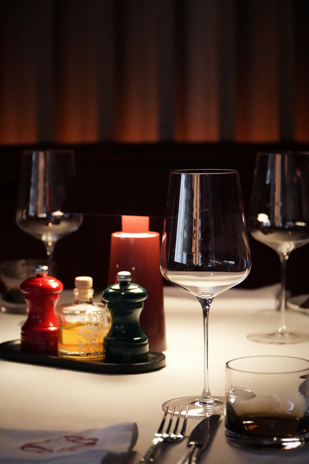 Verres à vin et salière en lumière basse, salon du soir de Jane